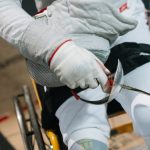 Close-up of a wheelchair fencer gripping a sabre, showcasing focus and determination in sport